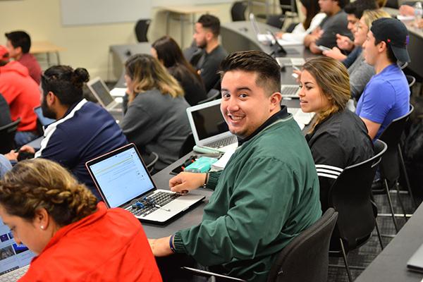 student smiles at camera during class