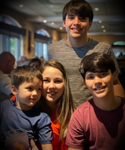 Hinojosa and her three sons smile at the camera