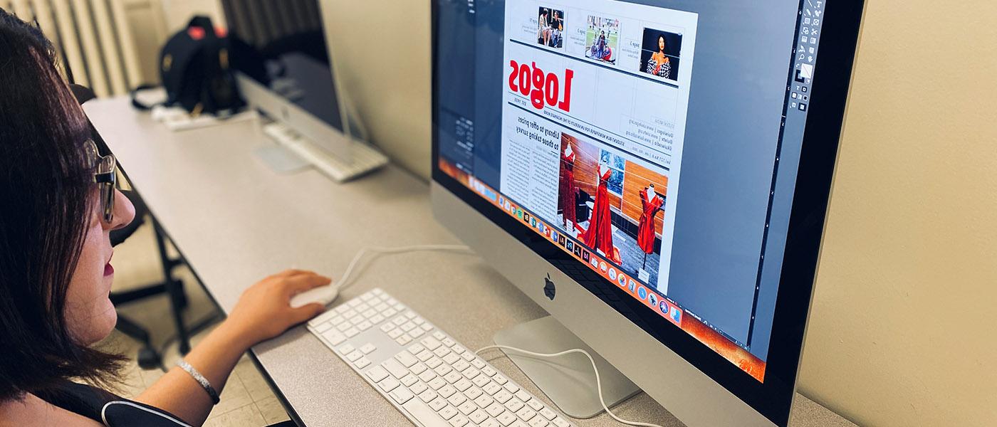 Student working on her computer laying out a Logos newspaper issue